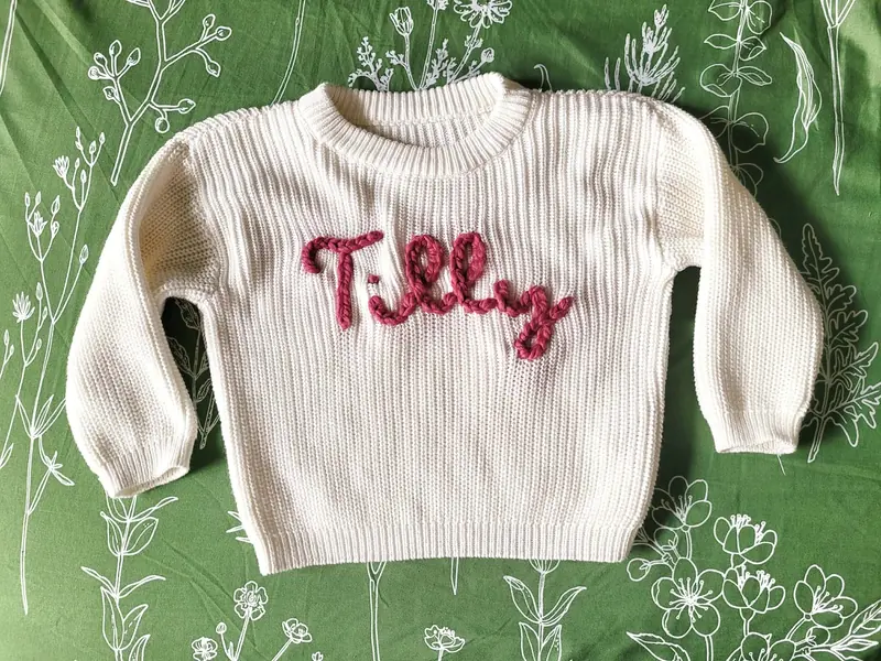 Cream sweater embroidered with the name Tilly