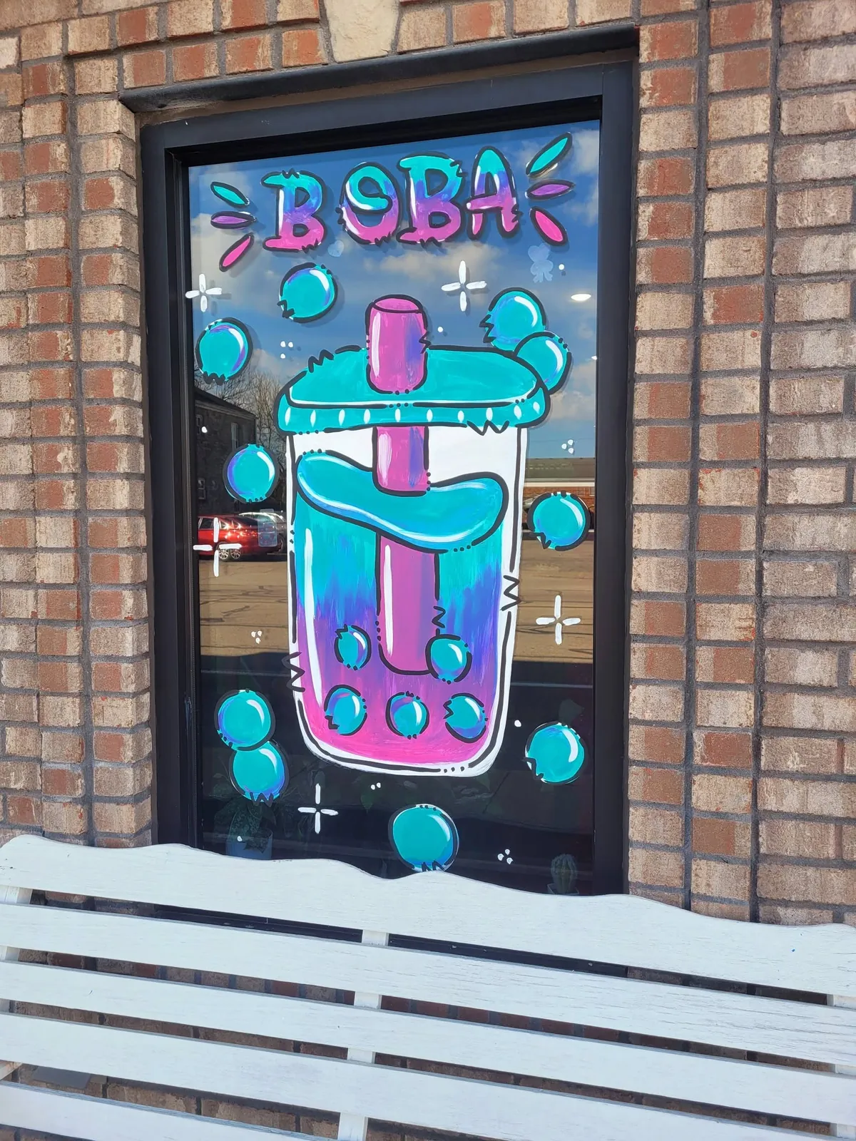 Window painted with a bright boba tea drink