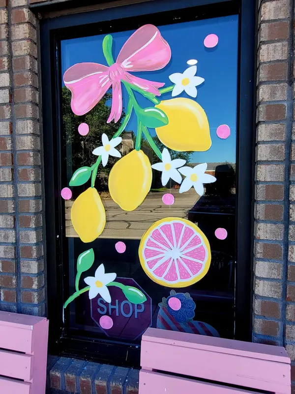 Window painted with lemons, flowers and a pink bow