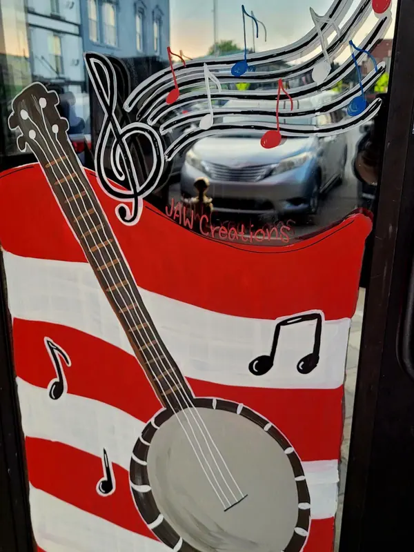 Window painted with a banjo and music notes over red and white stripes